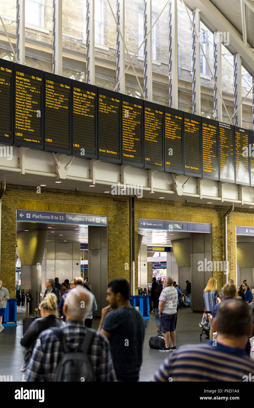 Pendler, der an der Zentrale elektronische Zug Aushänge in der halle des Bahnhof King's Cross, London, UK Stockfoto