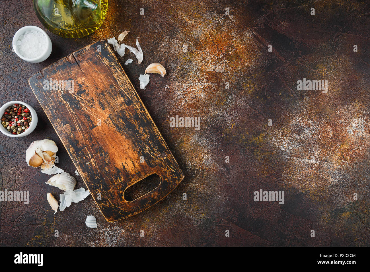 Holz Schneidebrett, Olivenöl, Salz, Pfeffer, Knoblauch und Thymian Zweige auf einem dunklen Hintergrund. Ansicht von oben kopieren. Platz für Text. Stockfoto