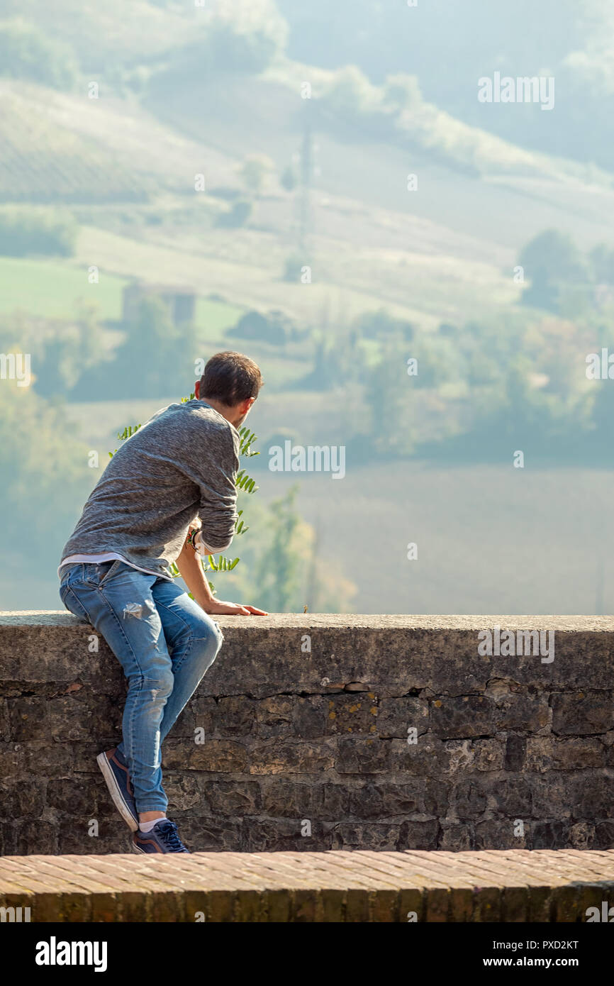 Rückansicht eines touristischen Mann sitzend beobachten, das Panorama, Castell'Arquato, Piacenza, Italien Stockfoto