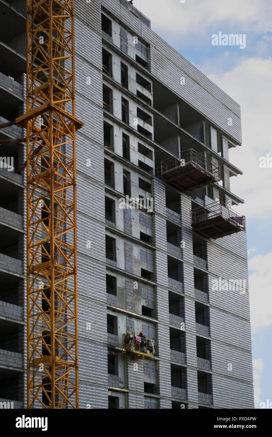 Die Konstruktion einer modernen Wohnhaus von monolithischen Beton und Ziegel auf dem Hintergrund der klare blaue Himmel, Wände, Fenster ein Stockfoto