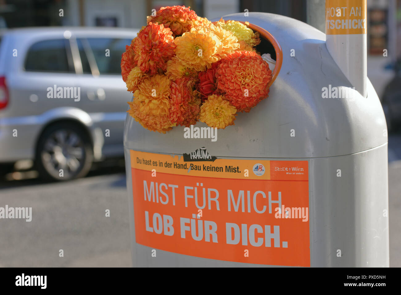 Wien, Österreich - 18 September 2018: Blumen in einem Papierkorb auf kann eine Straße von Wien. Das Etikett auf einer Müll kann sagt: Für mich, Lob an Sie Stockfoto