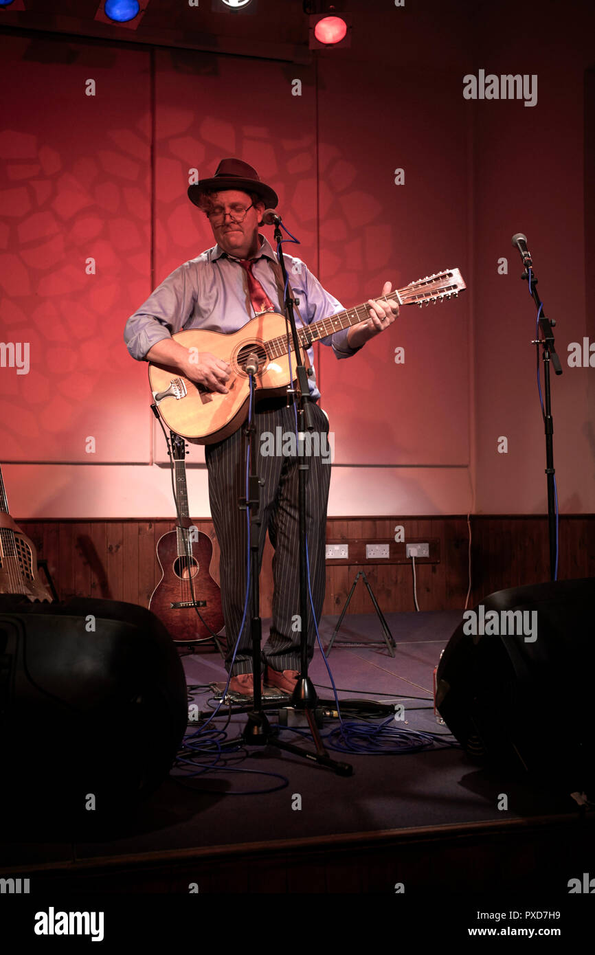Catfish Keith spielt auf der Bühne Laxey Institut in der Insel des Mannes mit seinem bawn 12-saitige Gitarre Stockfoto