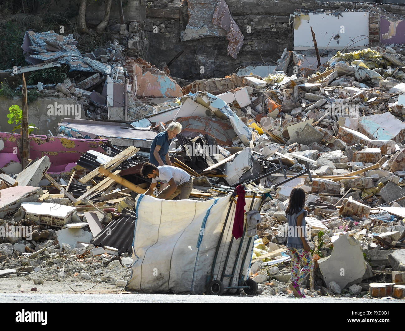 Istanbul, Türkei, 20. September 2018. Eine ältere, eine junge Männer und Mädchen Müll auf den Ruinen eines zerstörten Hauses sammeln. Stockfoto
