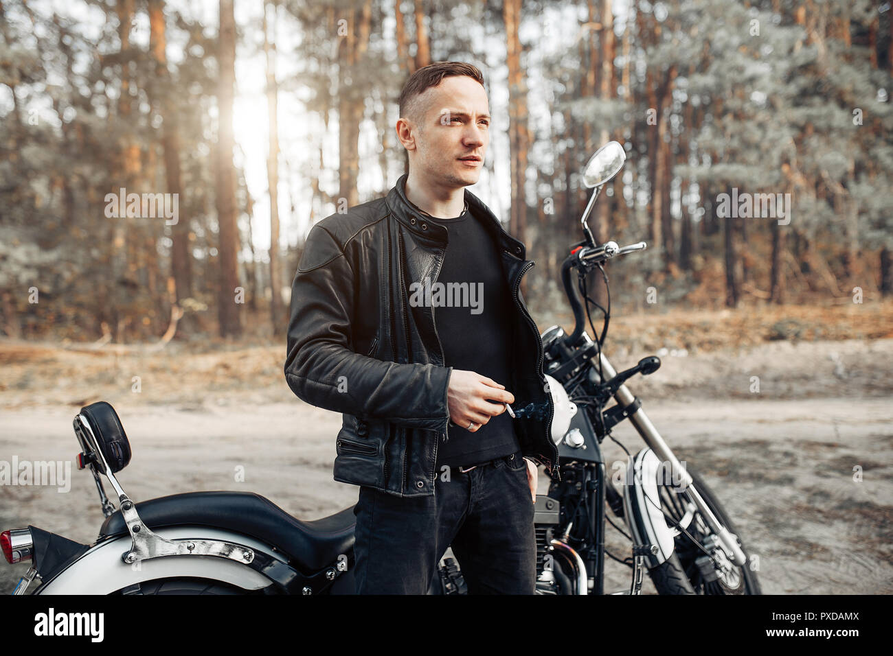 Stattliche rider Kerl in schwarzer Biker Lederjacke auf klassische Art Café  Racer Motorrad bei Sonnenuntergang. Bike custom in vintage Garage gemacht.  Brutale Spaß urba Stockfotografie - Alamy