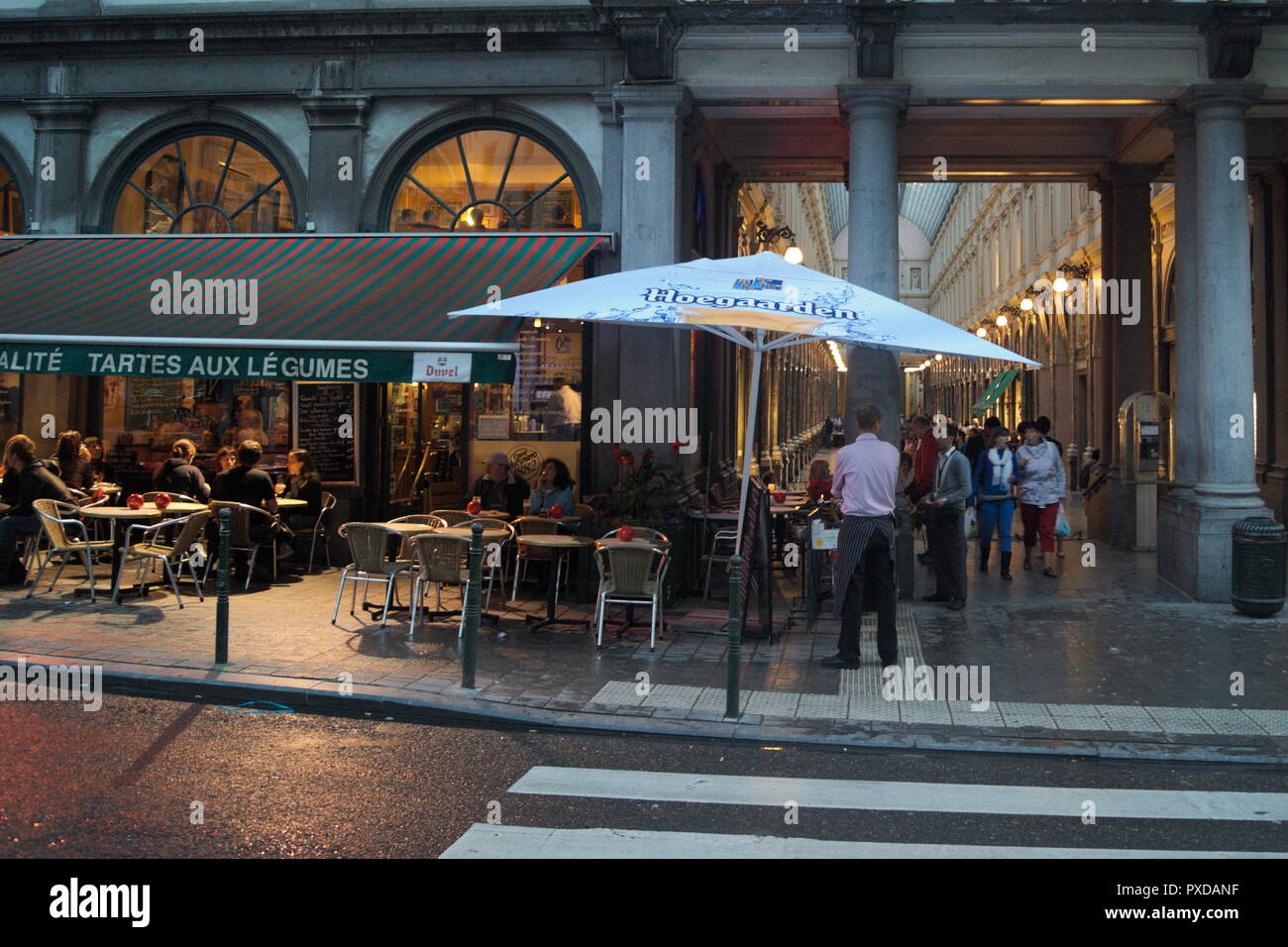 Blick bei Nacht auf ein elegantes Café – Restaurant und eine wunderschöne Einkaufspassage aus der Jahrhundertwende. Die Stadt Brüssel in Belgien. Stockfoto