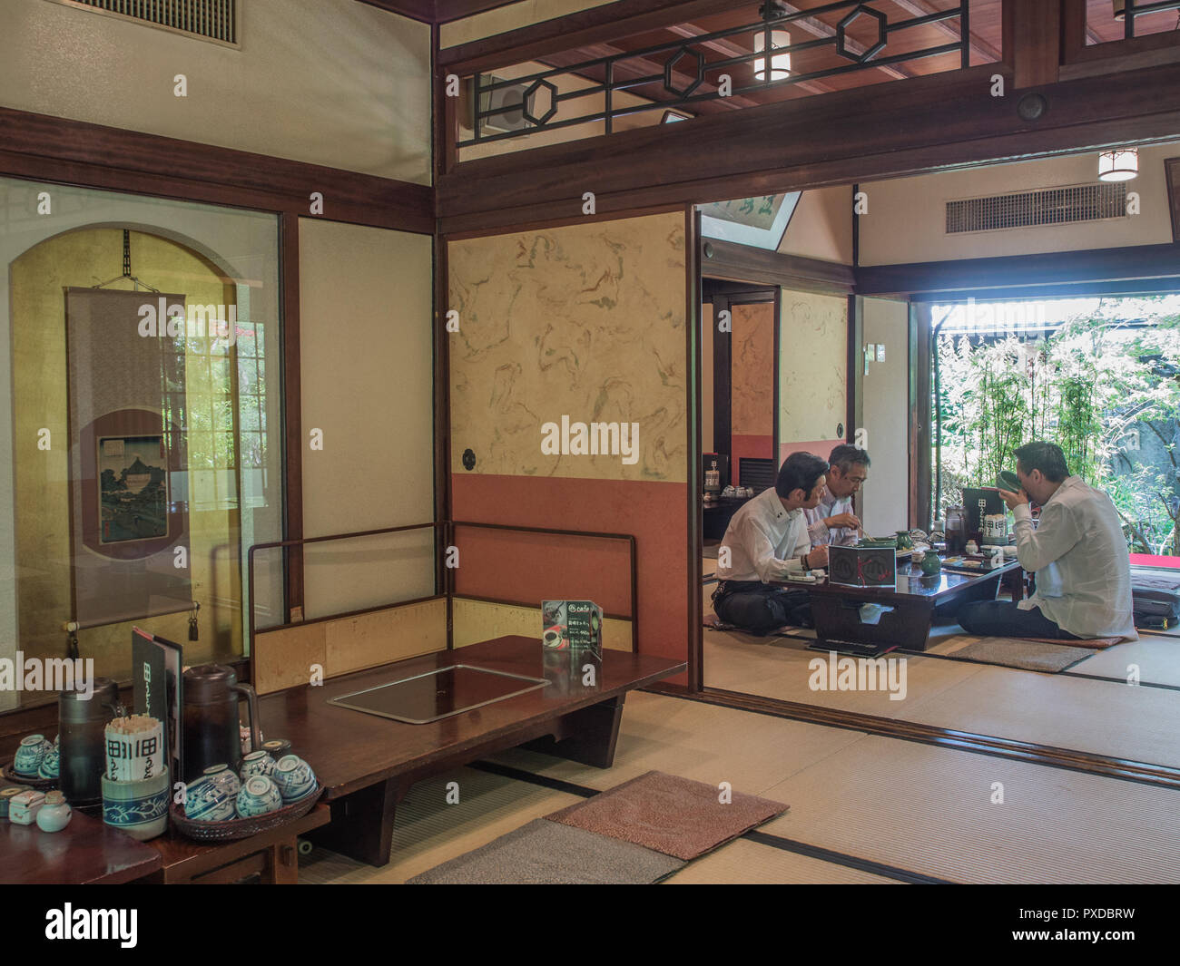 3 Drei Männer essen Essen, Sitzen im Schneidersitz bei niedrigen Tisch, Tatami-Matten, restaurant Udon Yamadaya, Takamatsu, Kagawa, Japan Stockfoto