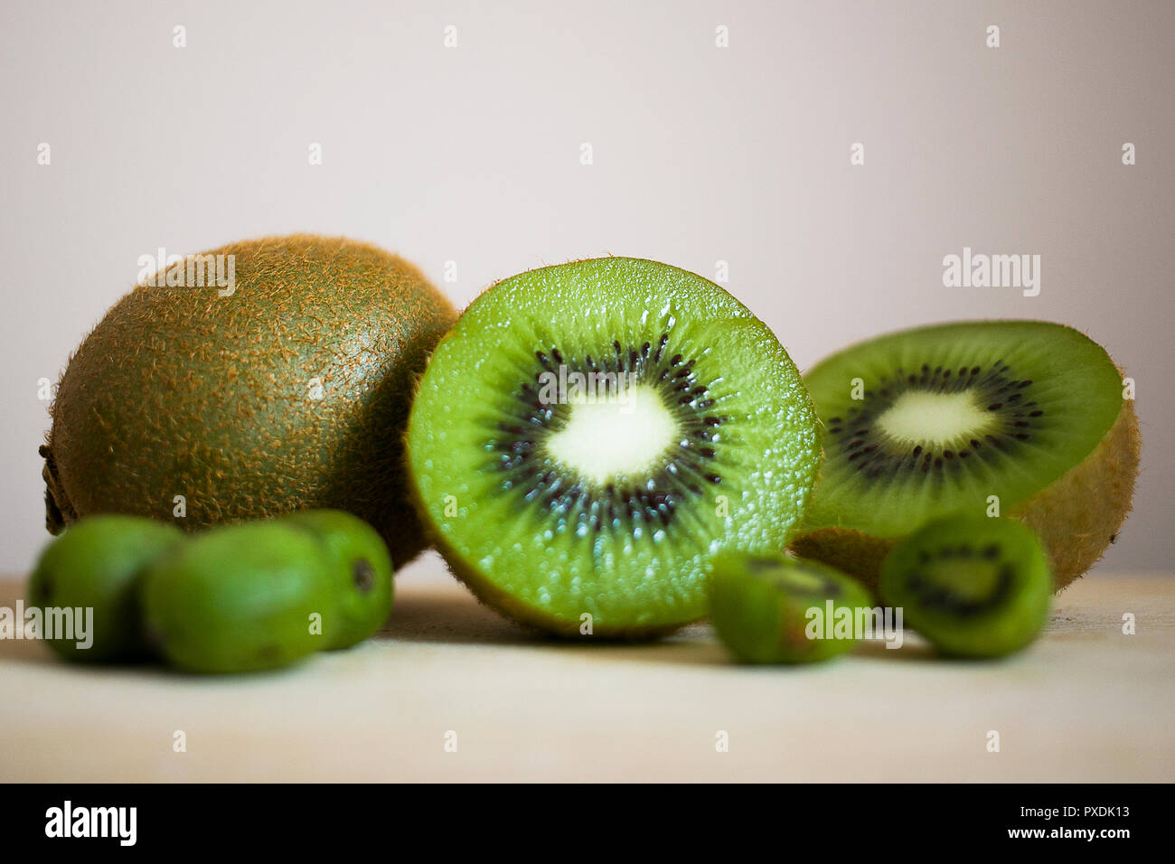 Köstliche Kiwi und Mini Kiwi in der Größe Vergleich Stockfoto