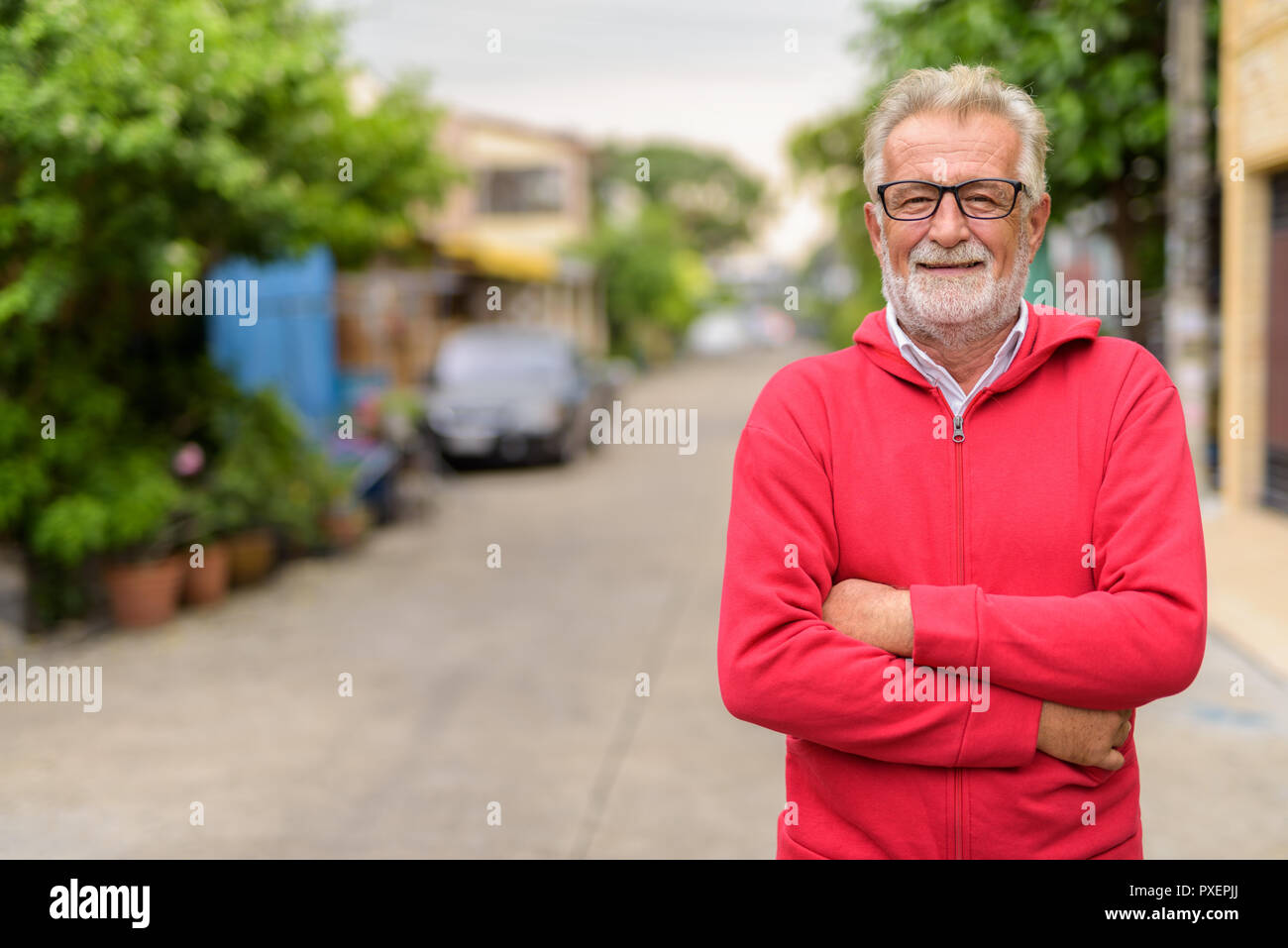 Glücklich aussehenden älteren bärtigen Mann lächelnd, während das Tragen von Brillen Stockfoto