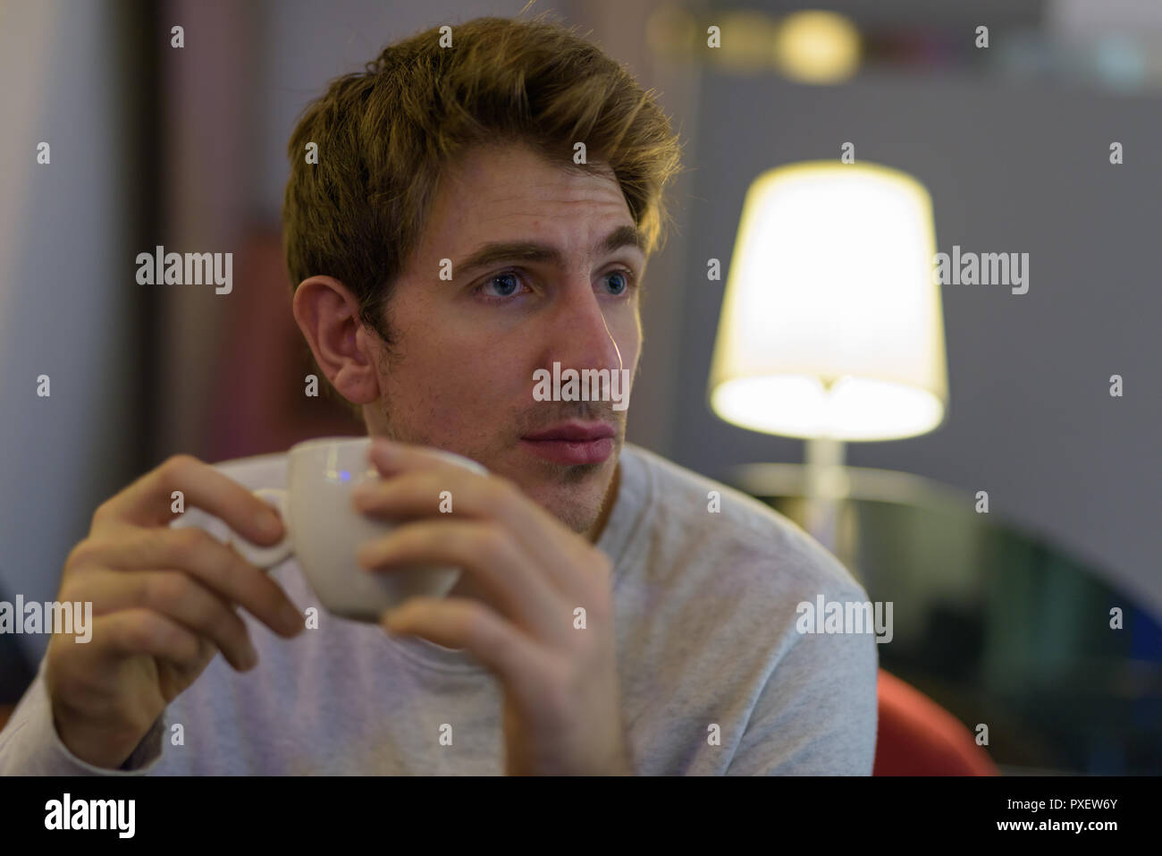 Portrait der kaukasischen Mann sitzt drinnen und trinken Kaffee Stockfoto