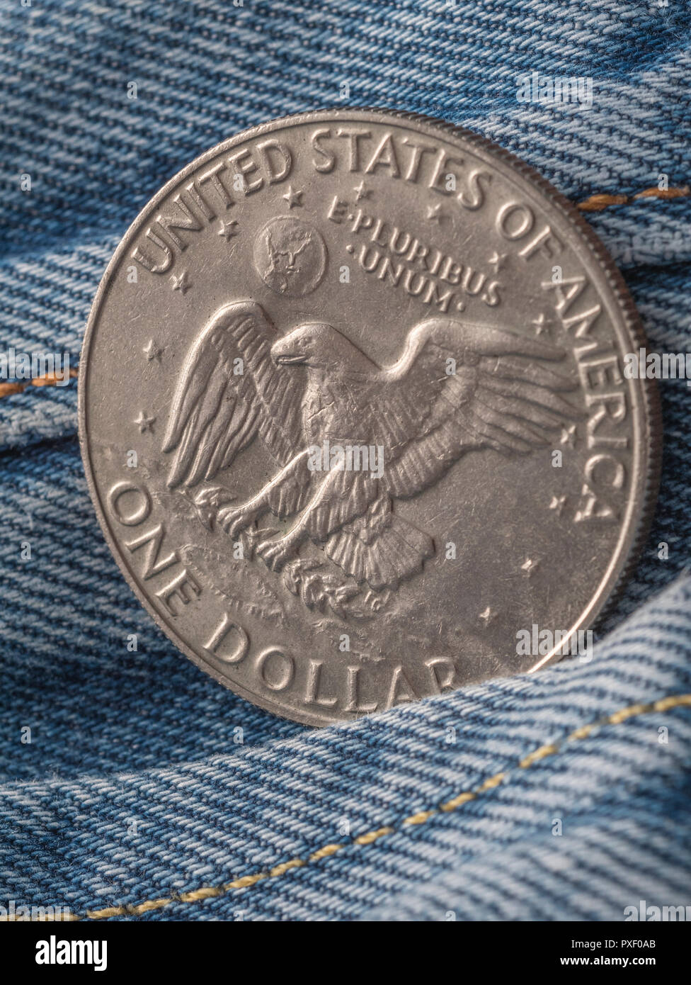 American Eagle & "E Pluribus Unum" Motto auf 1977 Eisenhower Silver Dollar, mit Tasche. Metapher US Dollar in der Tasche, oder das Geld in Ihre Tasche Stockfoto