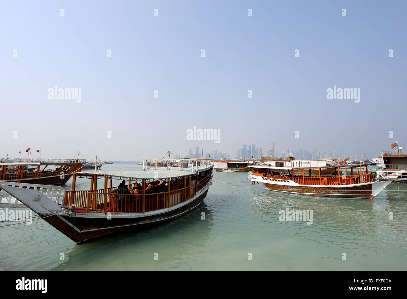 Doha/Katar - Oktober 10, 2018: traditionelle Dhows bis günstig entlang der Corniche in der katarischen Hauptstadt Doha, mit den Wolkenkratzern der West Bay Area Stockfoto