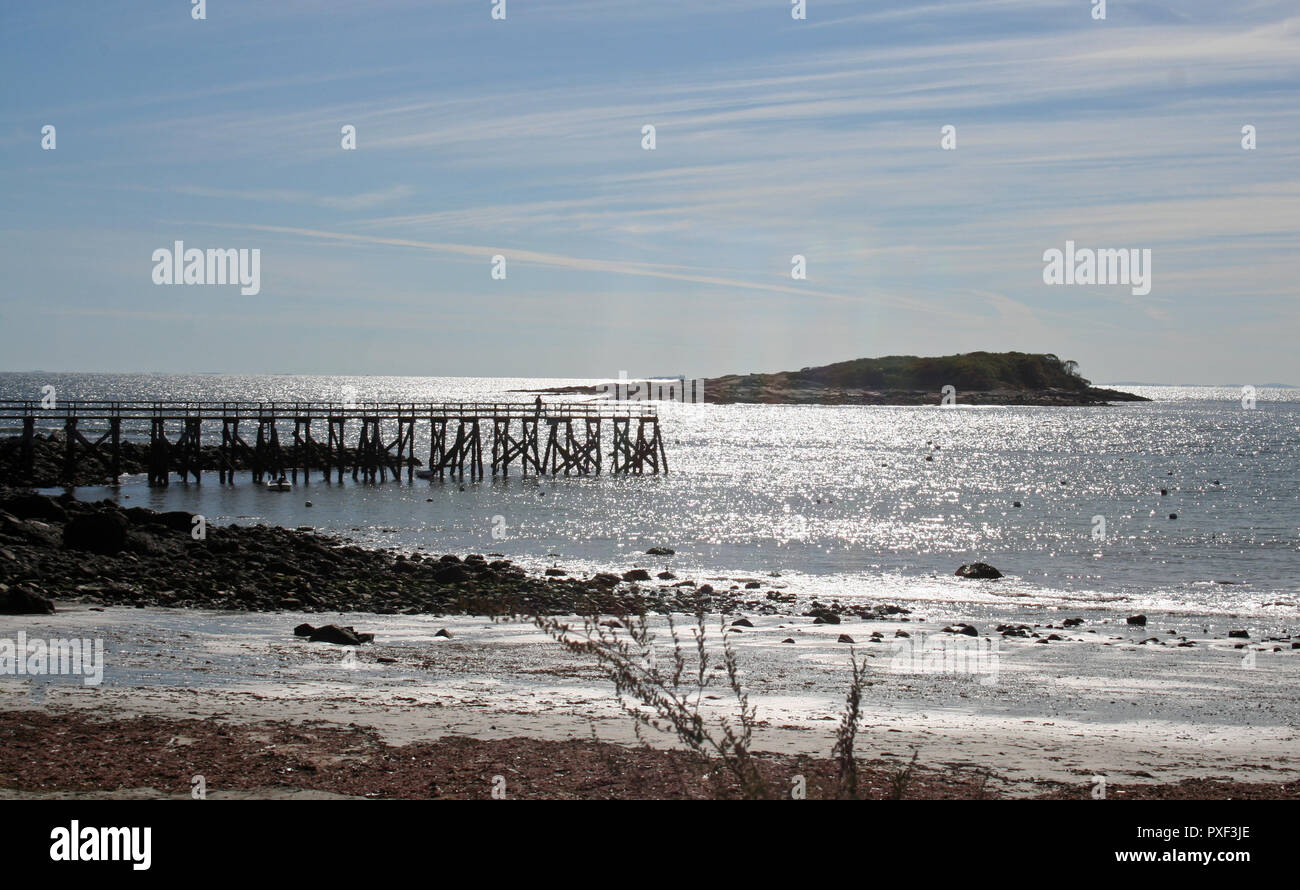 Magnolia Pier auf der Gloucester Massachusetts südlichsten Hafen seit Anfang 1800 durch die glitzernde Meer hervorgehoben, glitzernden Strand und blauer Himmel. Stockfoto