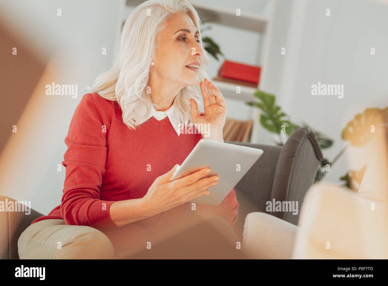 Charmante senior Frau mit Tablet-PC auf der Suche nach rechts Stockfoto