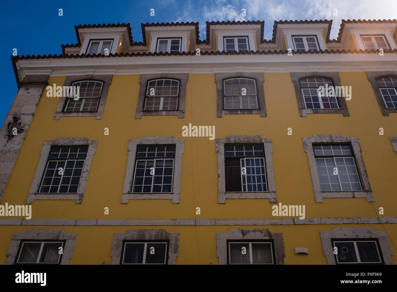 Von außen ein gelbes Gebäude mit Fenstern und blauen Himmel in Lissabon Portugal Stockfoto