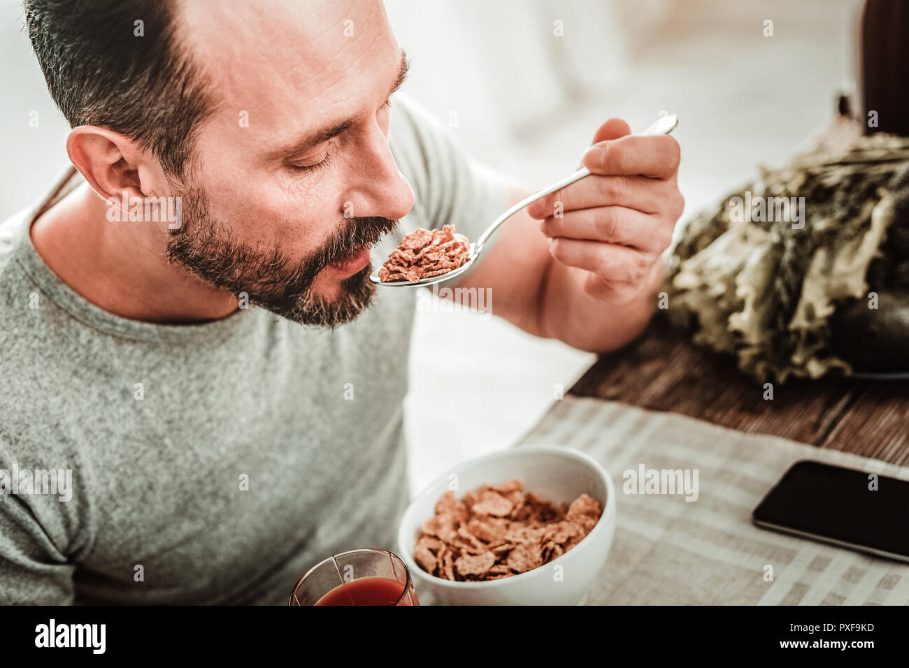 Angenehm nett aussehenden Mann mit einem Löffel Stockfoto