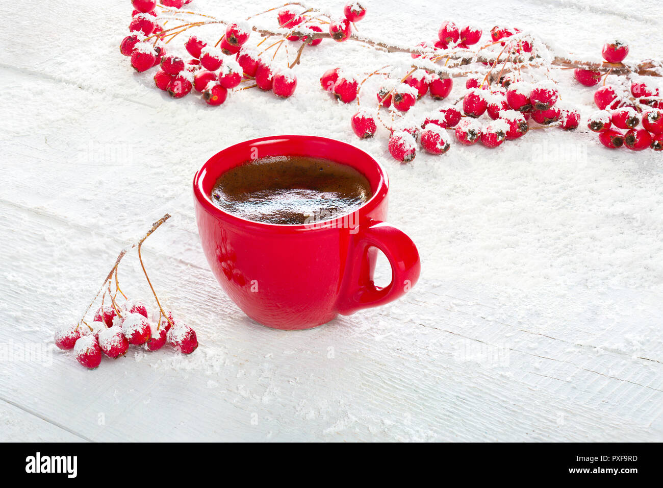 Rot Tasse Kaffee und Filialen mit Weißdorn-Beeren auf einem alten weißen Holz- Hintergrund. Stockfoto