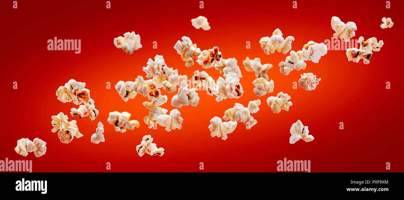 Popcorn isoliert auf roten Hintergrund. Fallende oder fliegenden Popcorn. Close-up Stockfoto