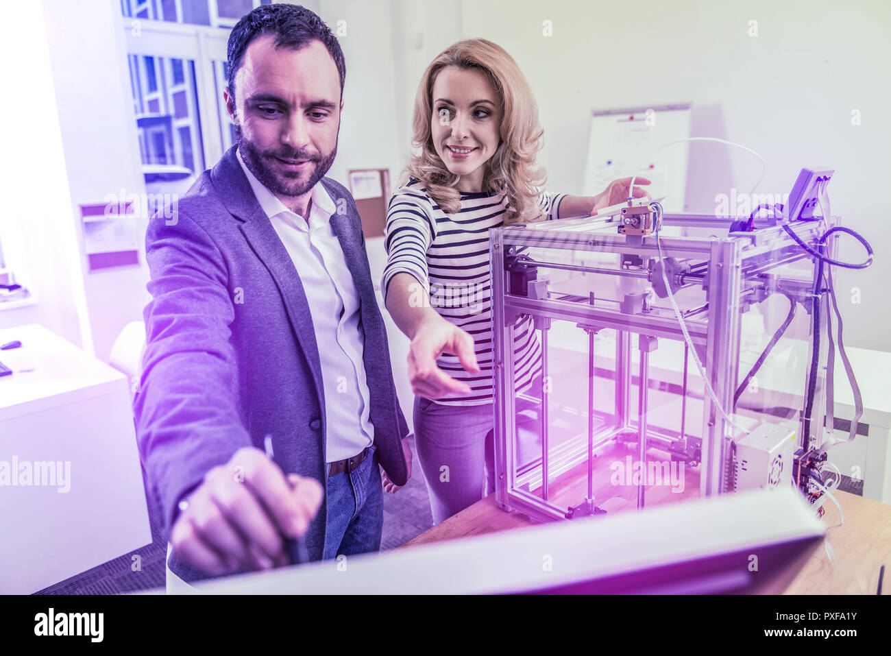 Zwei Geschäftsleute in Jeans arbeiten hart in ihrem grossen modernen Büro zusammen Stockfoto