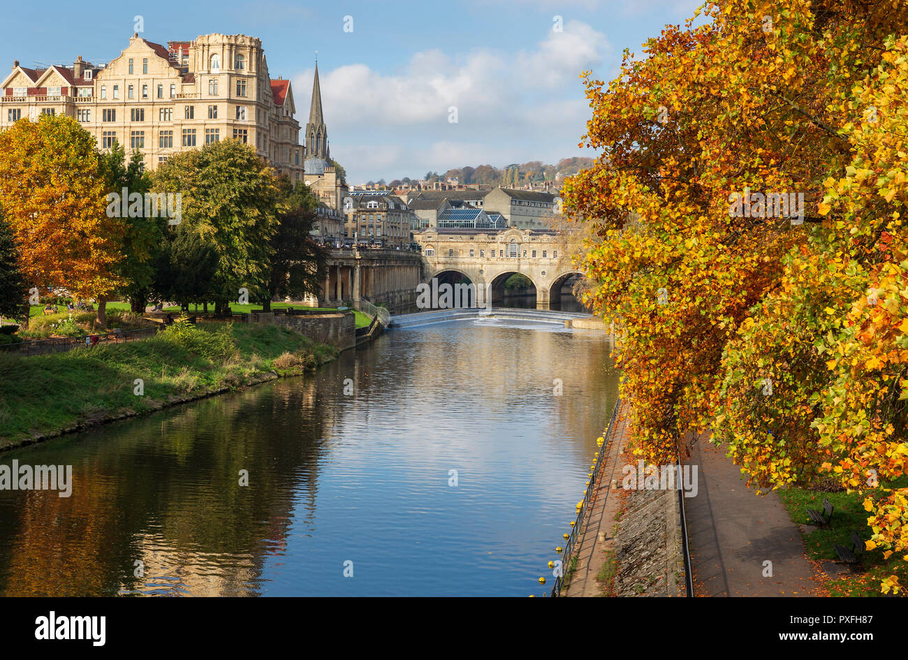 Die berühmten Sehenswürdigkeiten von Pulteney Wehr und Pulteney Bridge durch lebhaften herbstlichen Bäume am Fluss Avon in Bath, UK umgeben. Stockfoto