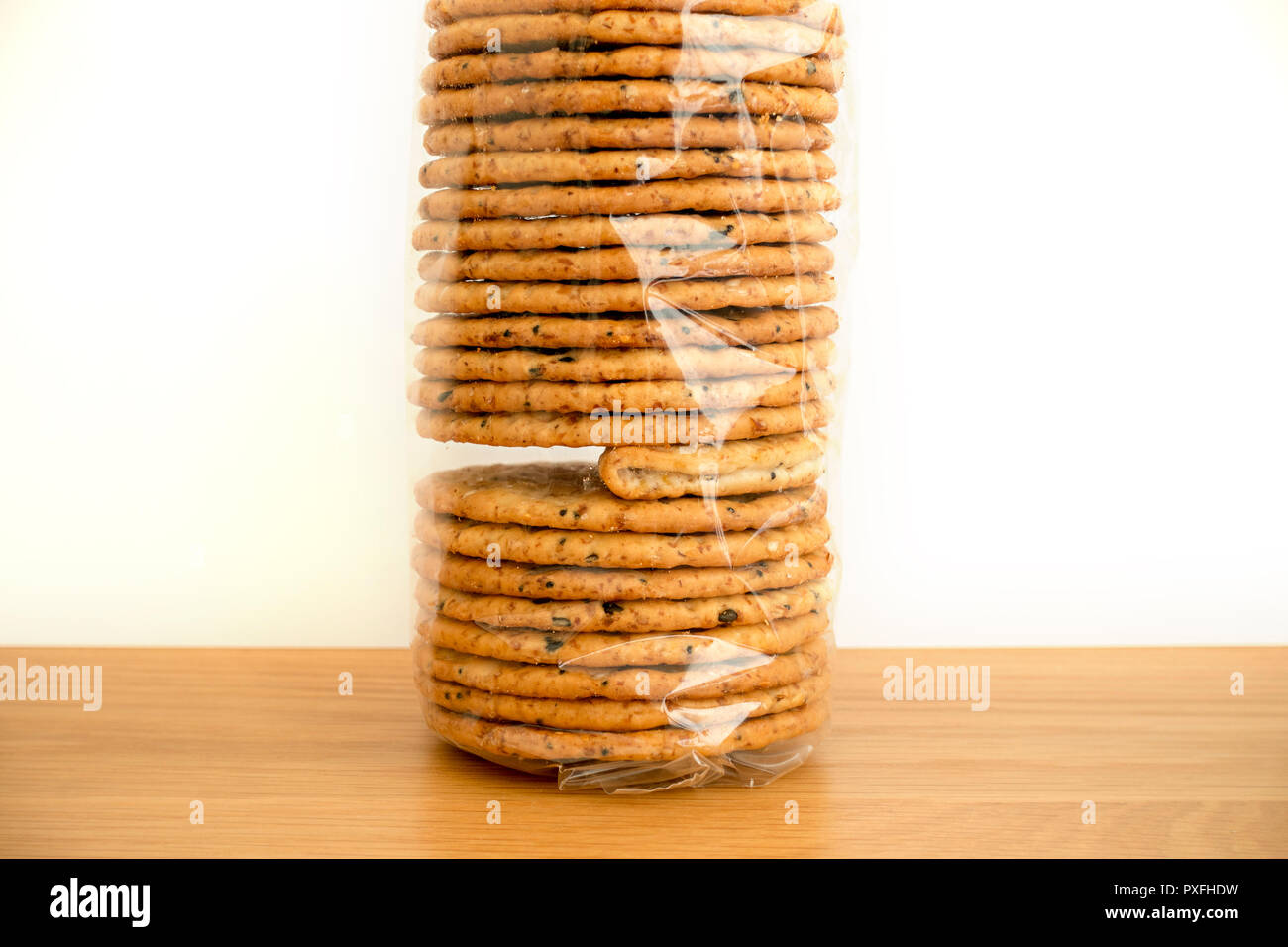 "Odd Man Out" ein Paket von klaren Zellophan verpackte Kekse mit einer fehlerhaften gefaltet Cracker verdeutlicht die Probleme oder Fehler in der Qualitätskontrolle. Stockfoto