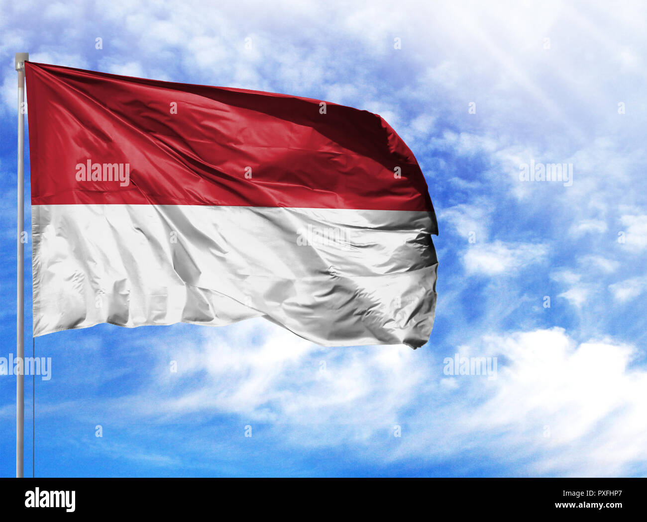 Nationalflagge von Indonesien auf einem Fahnenmast vor blauem Himmel. Stockfoto