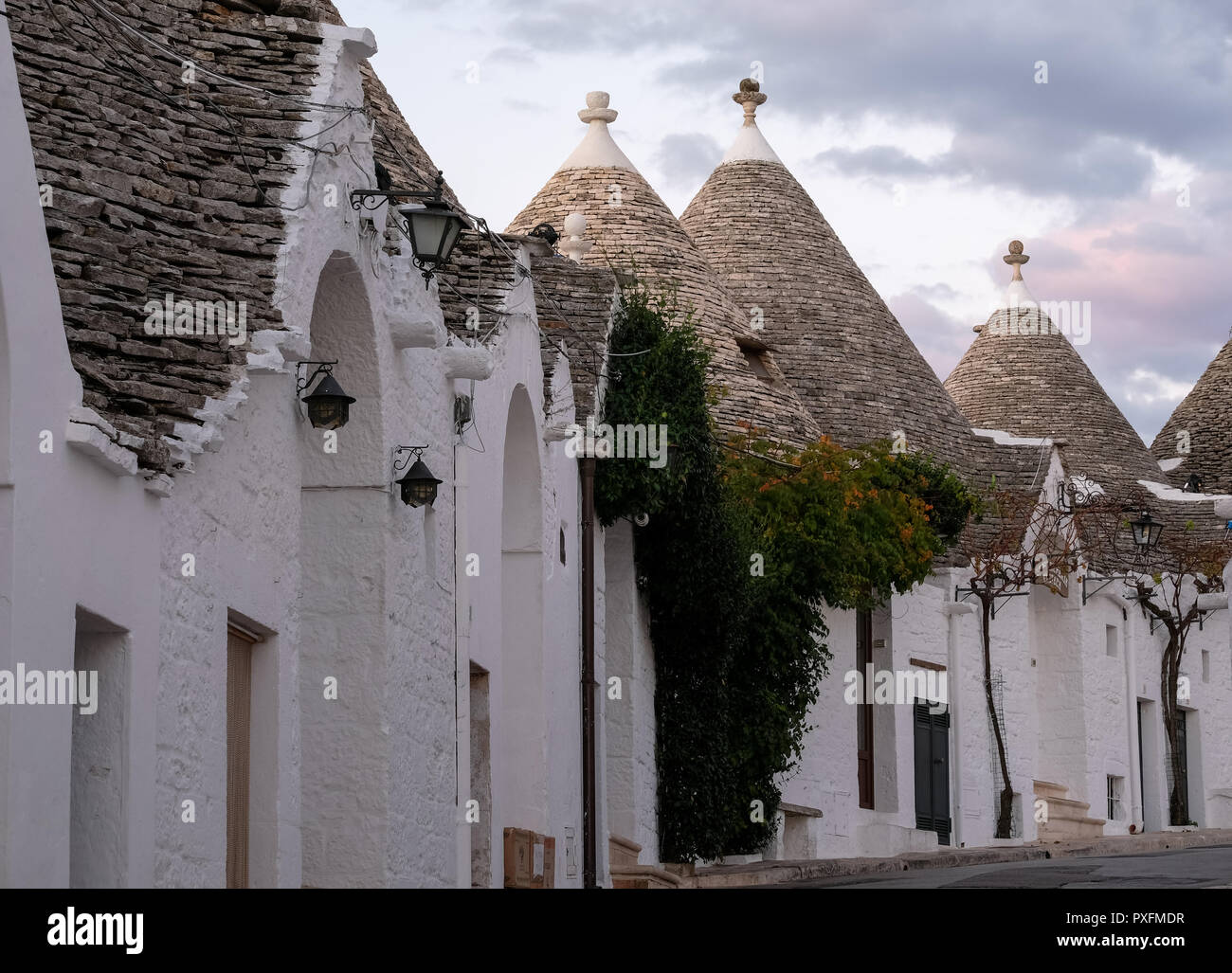 Ansicht der traditionellen weißen Trockenmauern Trulli auf einer Straße im Stadtteil Monti Bereich von Alberobello in Apulien, Italien. Stockfoto