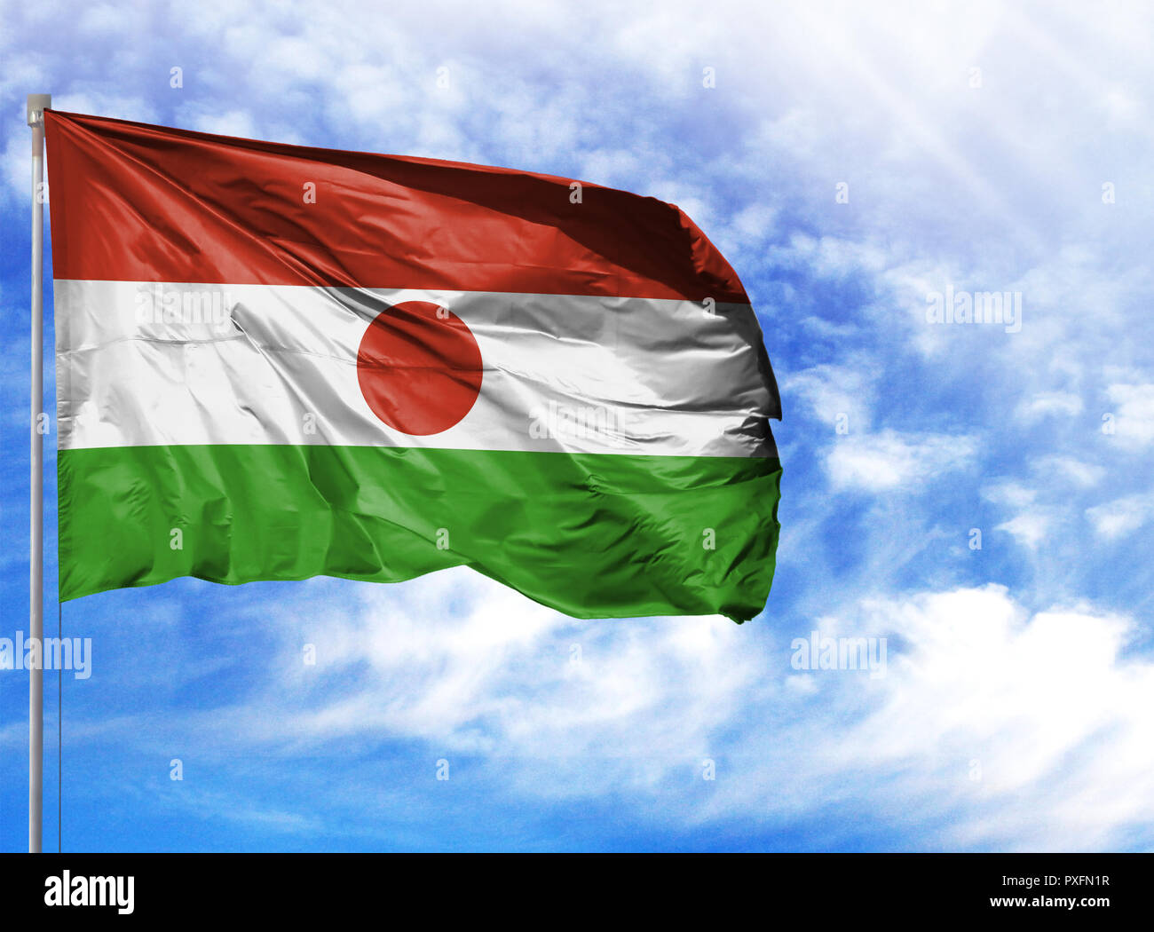 Nationalflagge von Niger an einem Fahnenmast vor blauem Himmel. Stockfoto