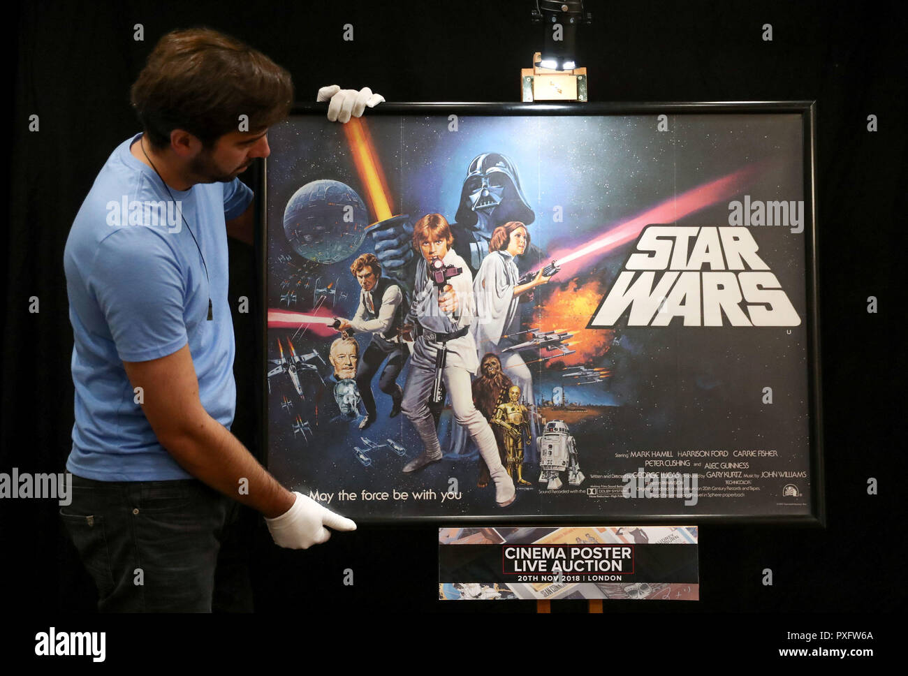 Prop Store Mitarbeiter Matt Geschichte hält ein Poster für den Film Star Wars 1977 während einer Vorschau auf die kommenden Kino Plakat Auktion an der Prop Shop Head Office in der Nähe von Rickmansworth. Stockfoto