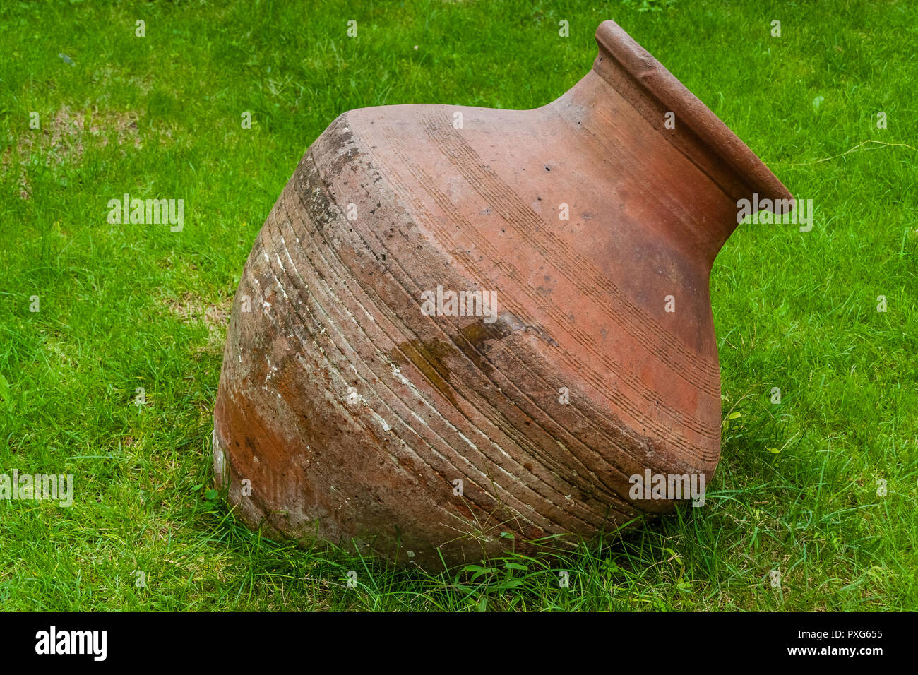 Alte terracotta Topf ruht auf etwas Gras. Stockfoto
