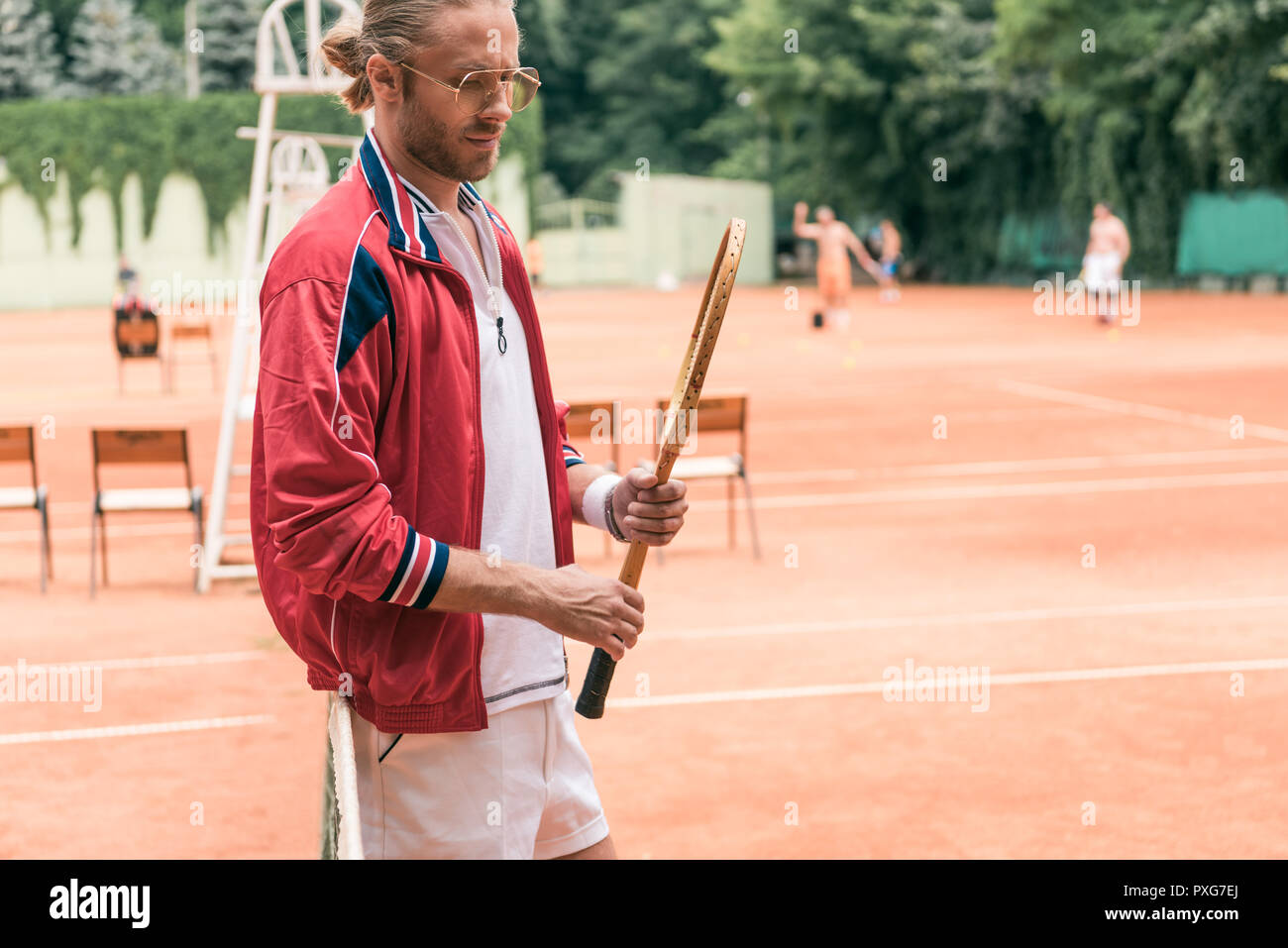 Schönen altmodischen Tennisspieler mit hölzernen Schläger am Netz auf dem Tennisplatz Stockfoto