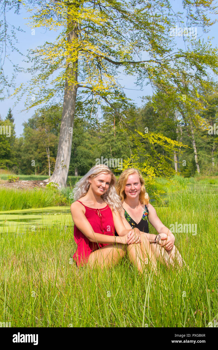 Blonden und rothaarigen Frau zusammen in der Natur sitzen Stockfoto