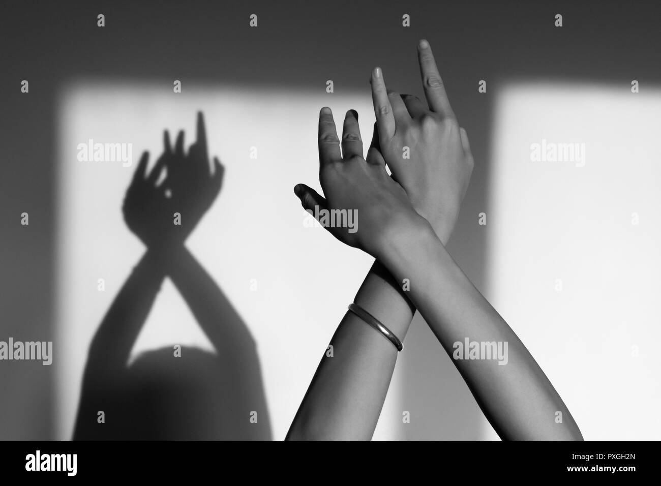 Weibliche Hände spielen mit Reflexionen in Schwarz und Weiß Stockfoto