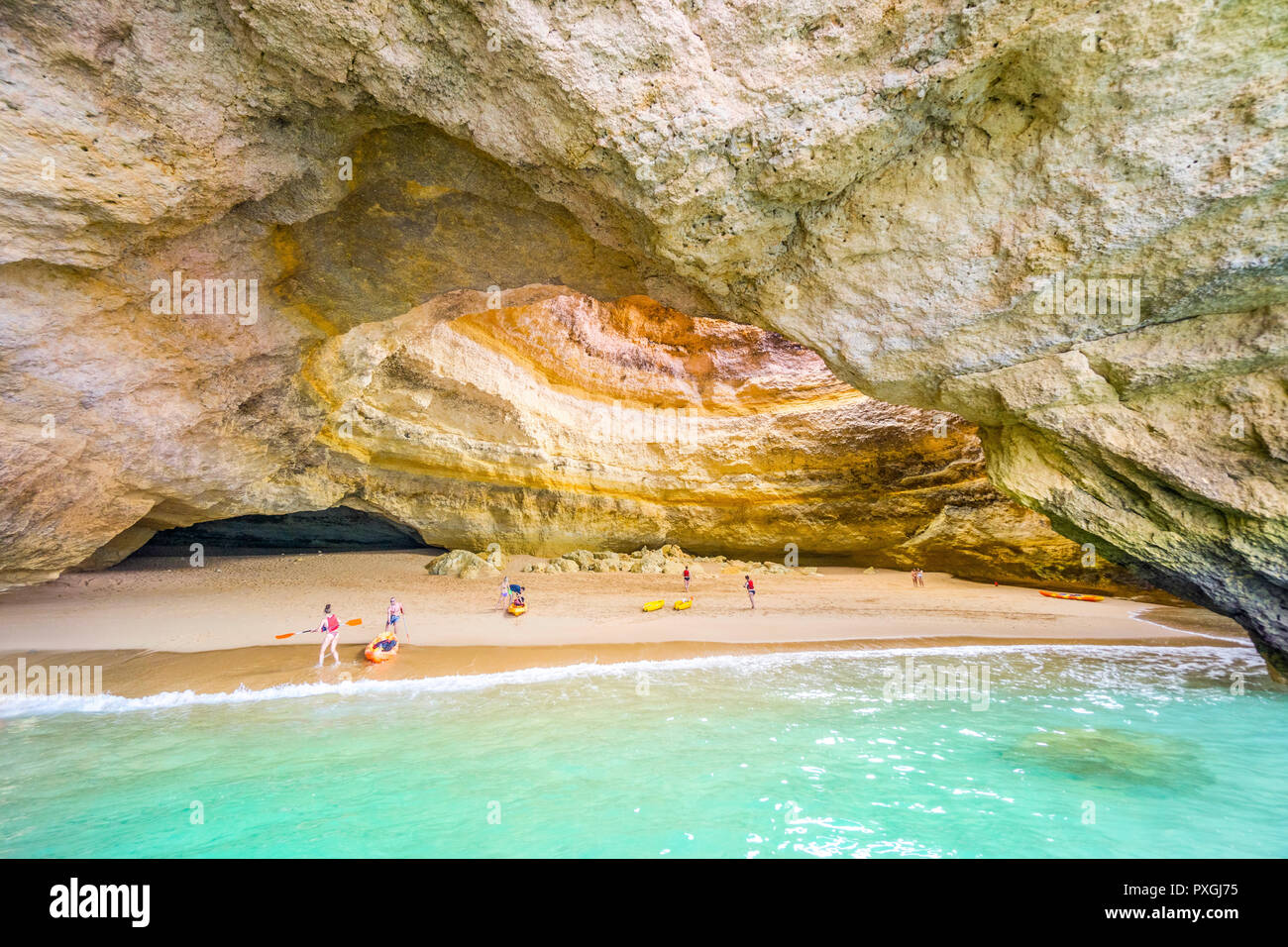 Touristische auf Kajaks genießen Sie herausragende Schönheit von Benagil Höhle, Algarve, Portugal Stockfoto