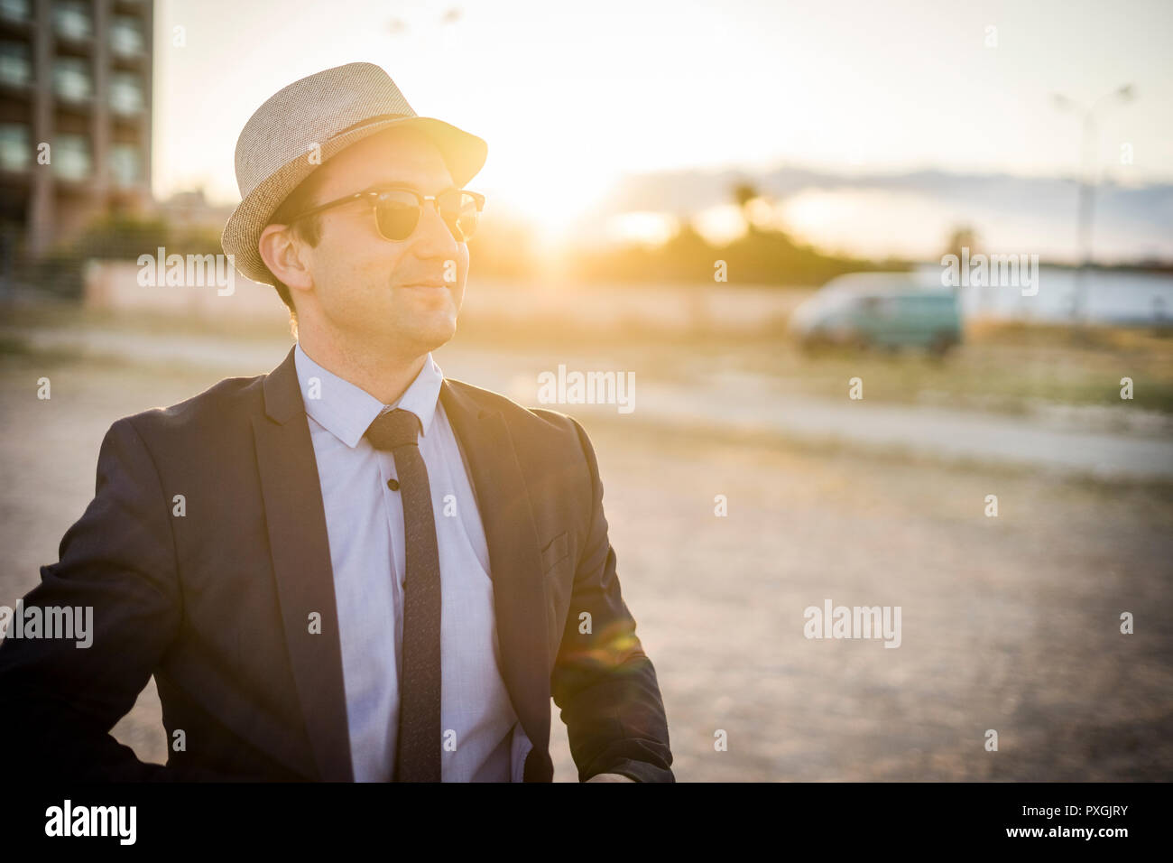 Lifestyle Portrait von Vintage suchen junger Mann in Anzug und Sonnenbrille bei Sonnenuntergang Stockfoto