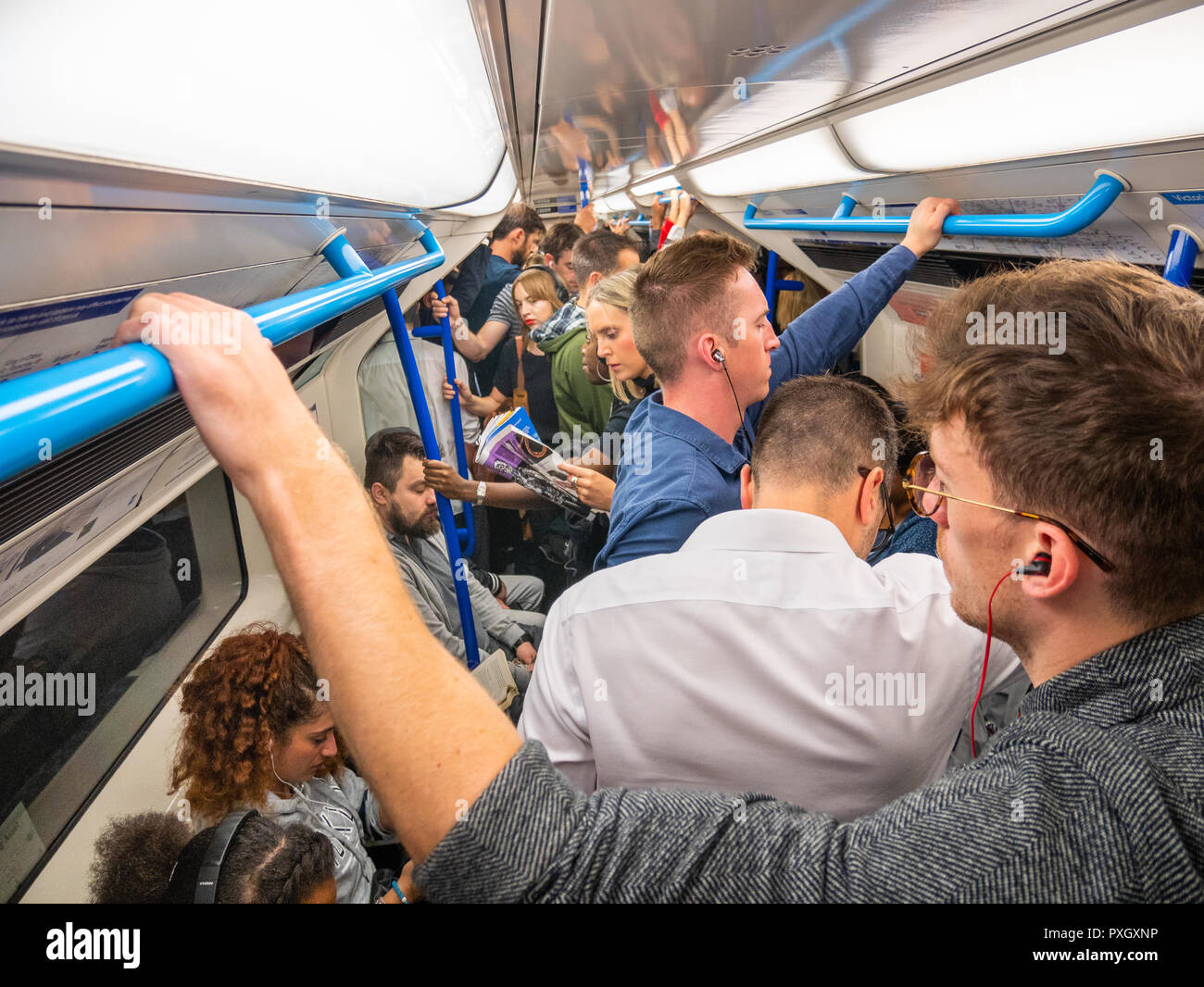 Pendler auf überfüllten Londoner U-Bahn im Berufsverkehr, Großbritannien Stockfoto
