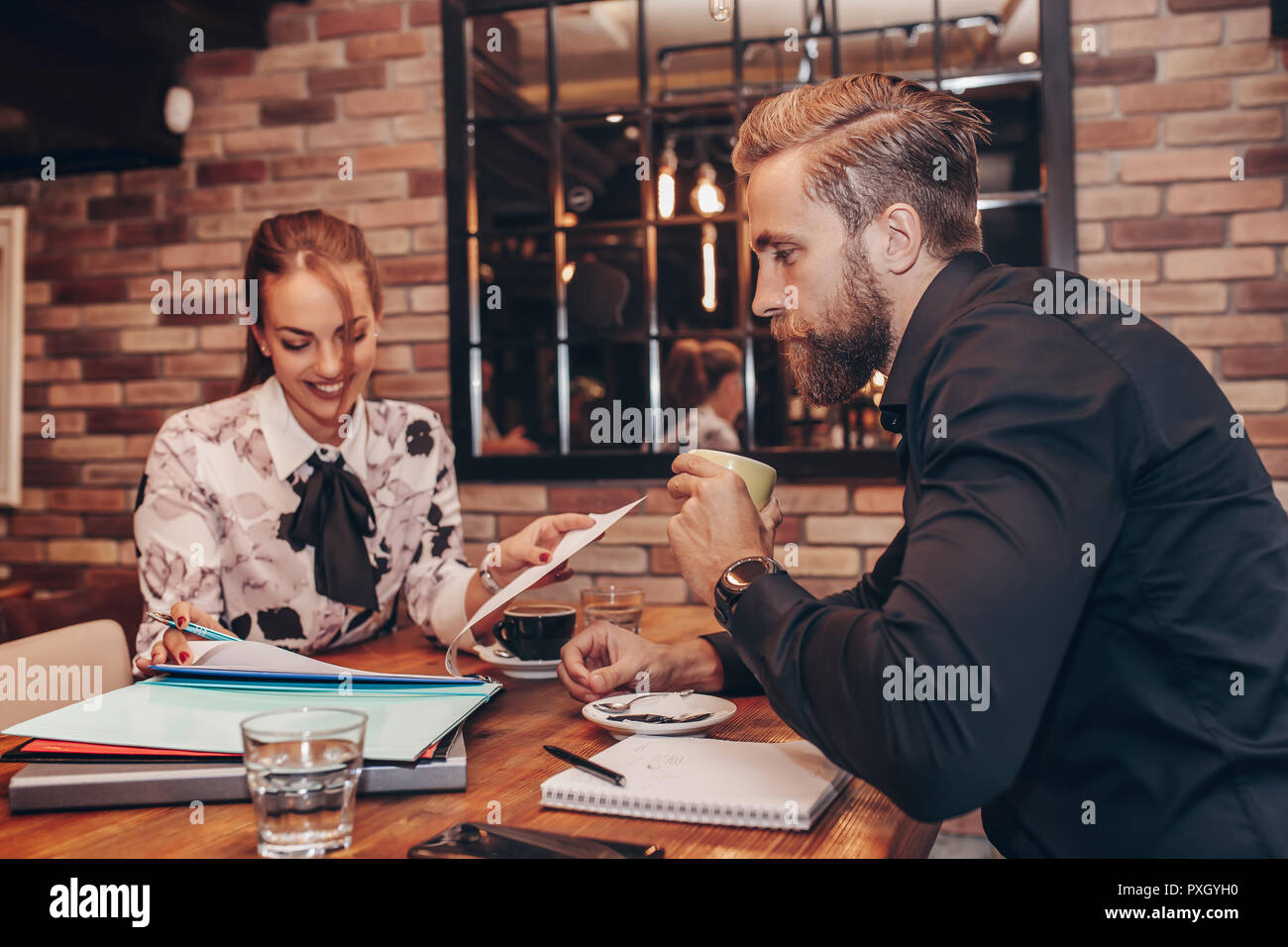 Junge Geschäftsleute zusammen Arbeiten auf Papier arbeiten und sprechen über Berichte und Finanz im Cafe. Stockfoto