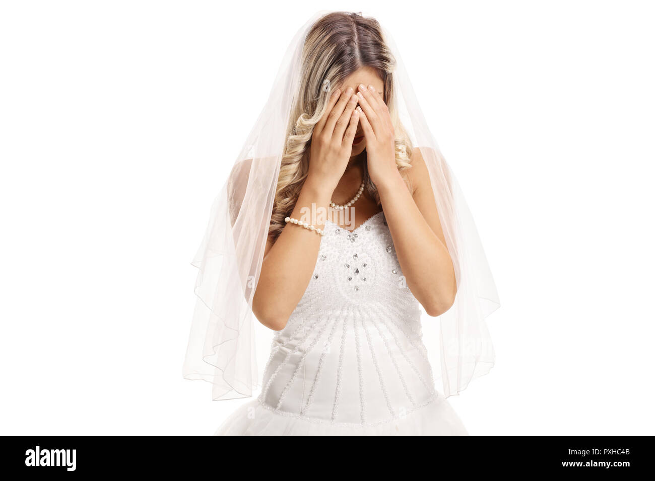 Traurige Braut, die ihr Gesicht mit den Händen auf weißem Hintergrund Stockfoto
