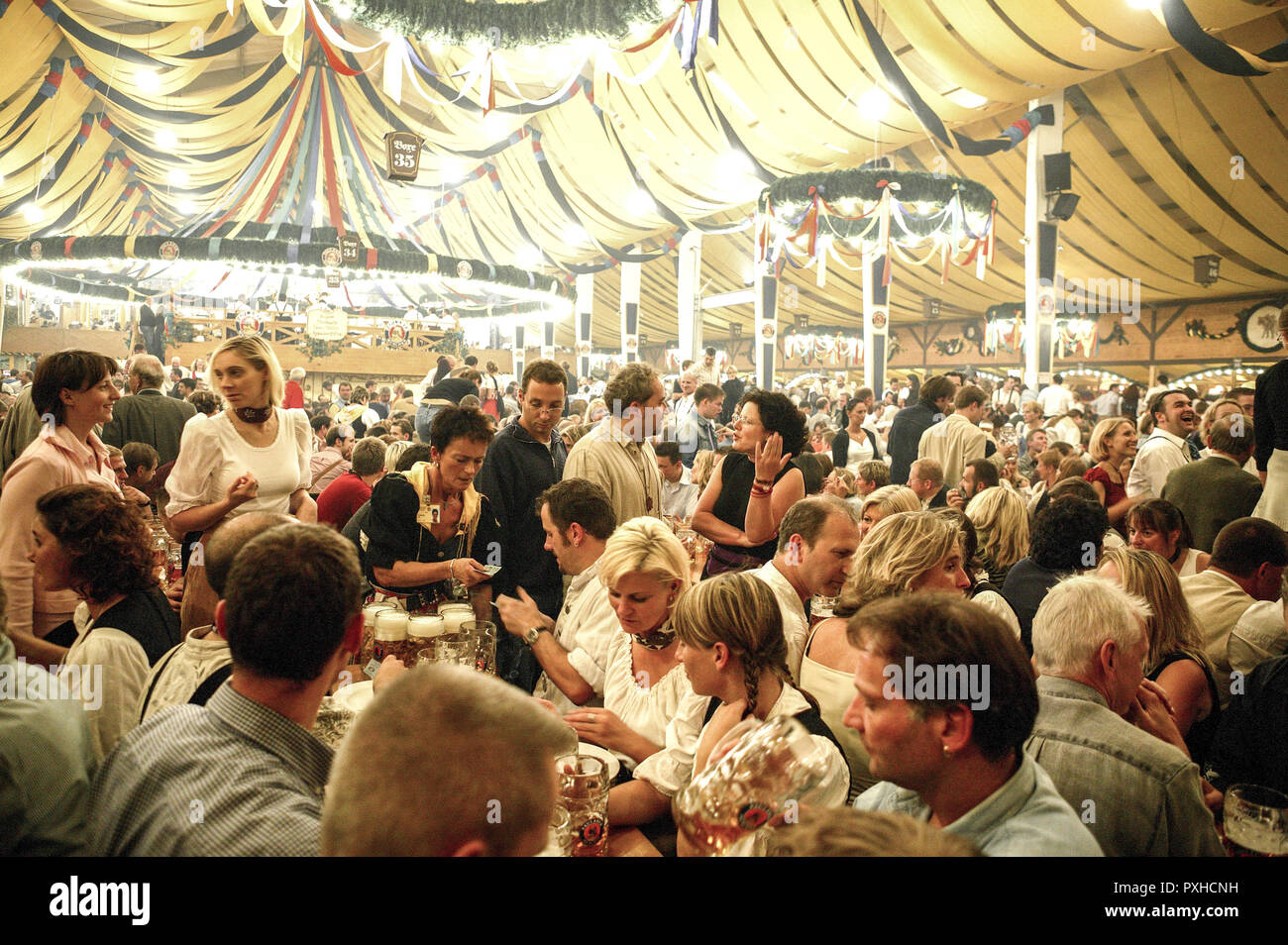Glückliche Menschen im Bierzelt, das Oktoberfest in München. Stockfoto