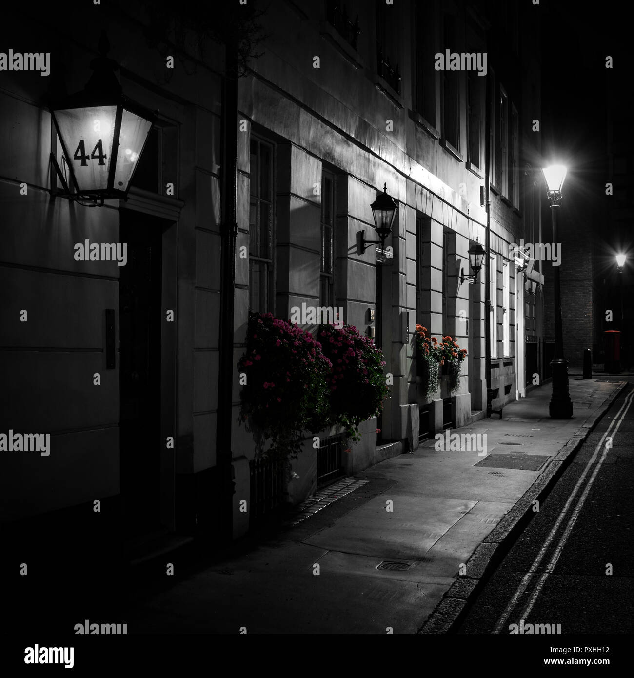 Nacht Bild der Reihenhäuser mit Blumenkörben außerhalb und Straßenlaternen entlang St James's Place, London, England Stockfoto