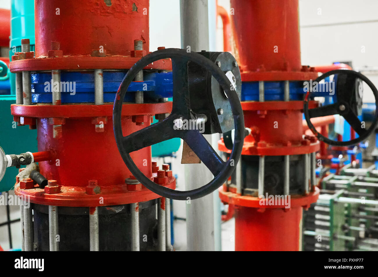 Schieber auf Rohren in Rot lackiert installiert. Industrielle Hintergrund. Stockfoto