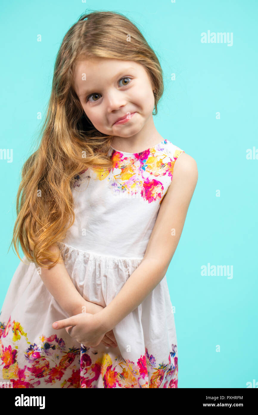 Süße kleine Mädchen mit einem Blumen Sommer Kleid isoliert auf Blau Stockfoto