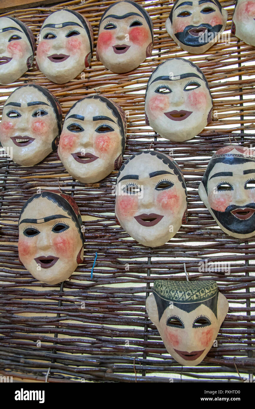 Papier pappmaché Masken von Männern und Frauen in traditionellen Schals und Mützen in Samarkand, Usbekistan. Stockfoto