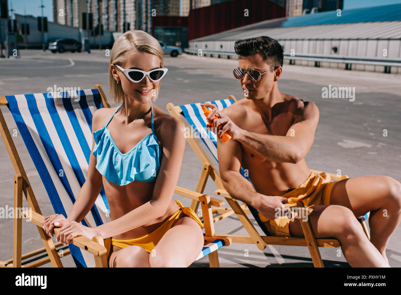 Jungen gutaussehenden Mann Anwendung von Sonnencreme auf Freundinnen wieder auf Parkplatz Stockfoto