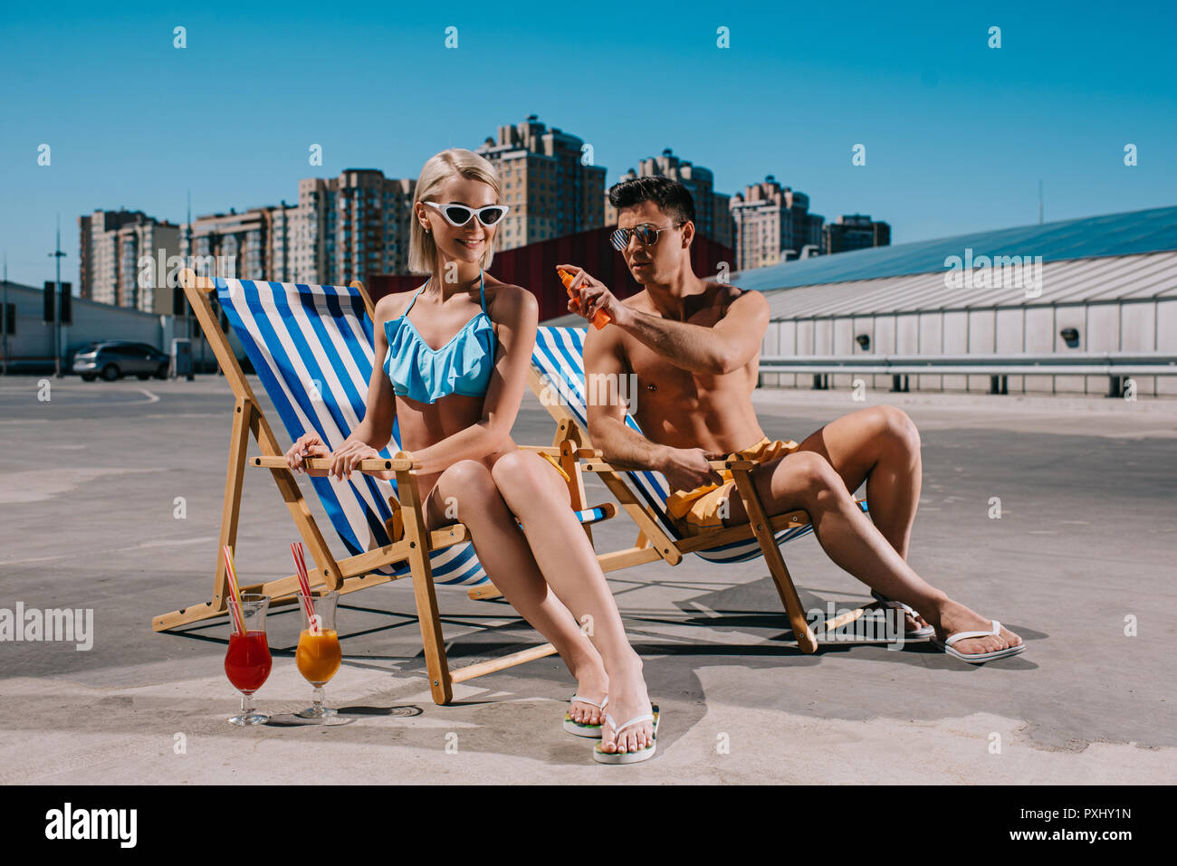 Jungen attraktiven Mann Anwendung von Sonnencreme auf Freundinnen wieder auf Parkplatz Stockfoto
