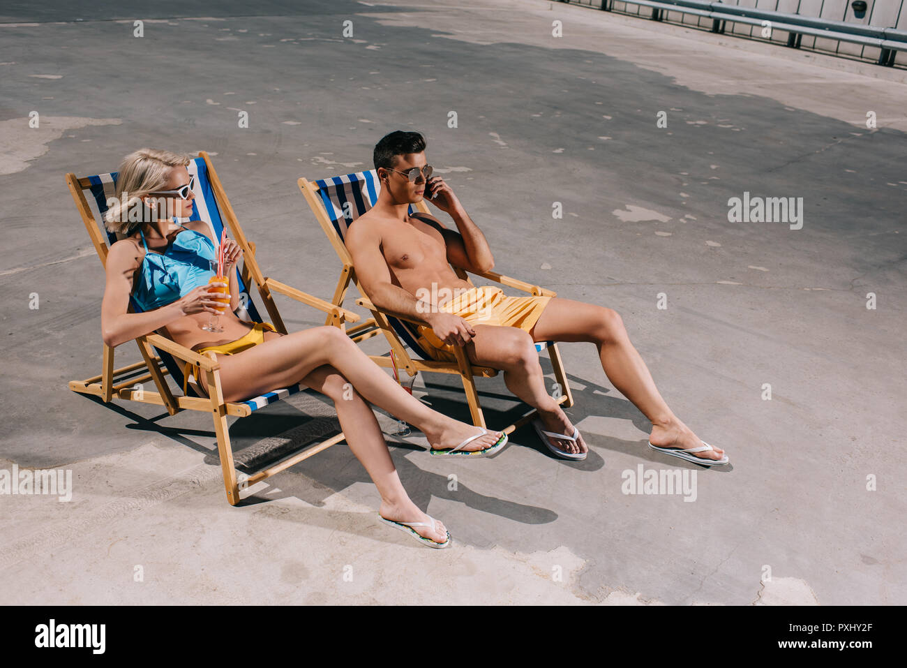 Hohe Betrachtungswinkel von junges Paar entspannende auf Liegestühlen entspannen auf Parkplatz Stockfoto