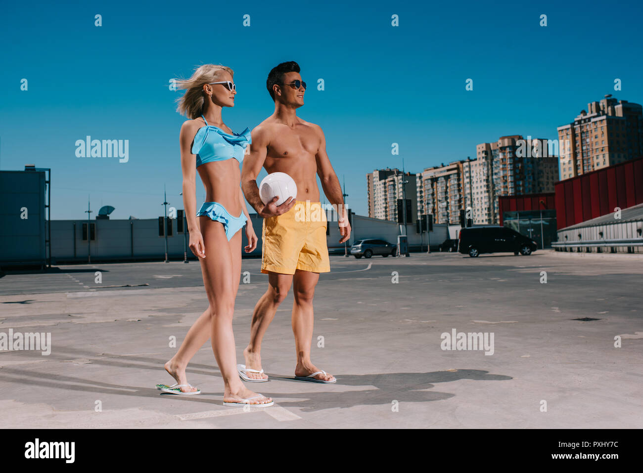 Junges Paar am Strand Kleidung mit Volleyball Ball auf Parkplatz Stockfoto