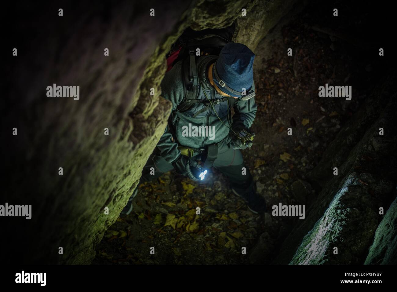 Kaukasische Höhlen Explorer mit Kompass Gerät für die rechte Weise außerhalb Suchen. Stockfoto