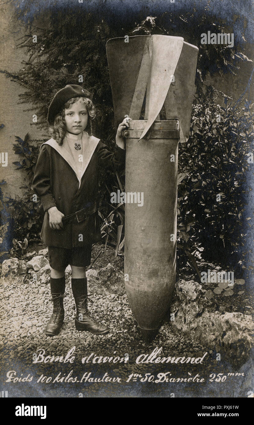 WW1 - kleines französisches Kind mit einer riesigen, nicht explodierten deutschen Bombe Stockfoto