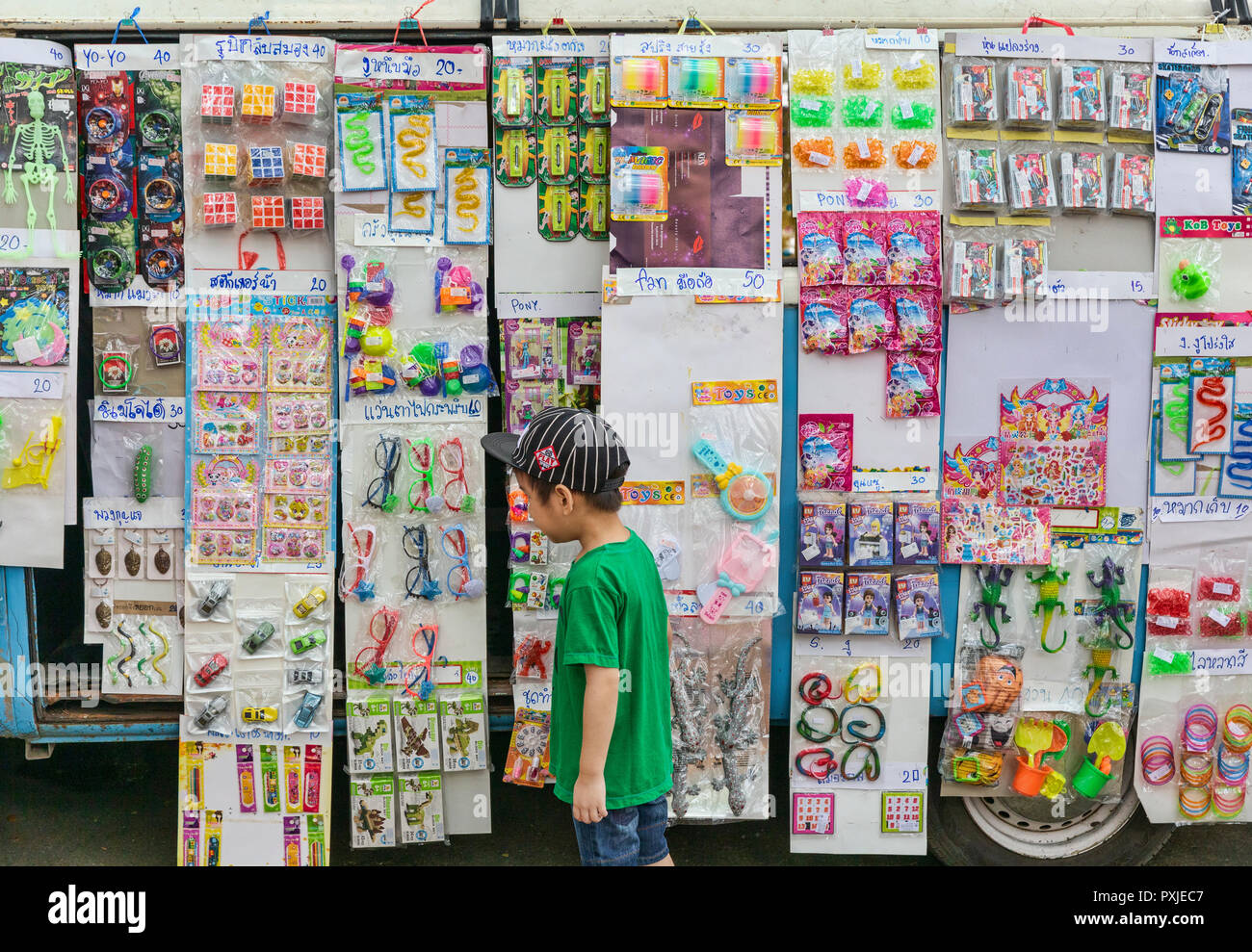Junge schaut auf Spielzeug für Verkauf an den umgebauten VW-Transporter pop up Toy Shop am Markt JingJai Farmer's, Chiang Mai, Thailand Stockfoto