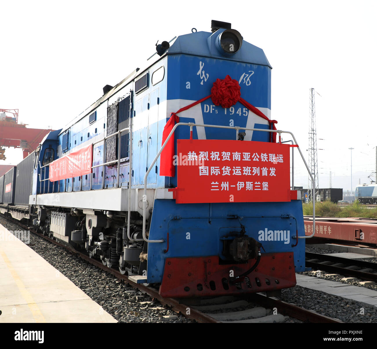 (181023) - LANZHOU, Oktober 23, 2018 (Xinhua) - ein Zug mit 30 Wagen der mechanischen Ausrüstung, Auto Teile und täglichen Notwendigkeiten gesehen wird zu einem Logistikzentrum in Lanzhou im Nordwesten der chinesischen Provinz Gansu, Okt. 23, 2018. Wurde eine neue Schiene und Straße Cargo Service Dienstag gestartet, die Verknüpfung von Lanzhou mit Islamabad in Pakistan. Der erste Zug links das Logistikzentrum am Dienstag Morgen, nach Kashgar in Xinjiang Uygur Autonome Region gebunden. Die Ware wird dann nach Islamabad durch eine Autobahn transportiert werden. Dies war das zweite güterzug Service von Gansu nach Südasien gestartet. (Xinhua/Li Jie) (mcg) Stockfoto